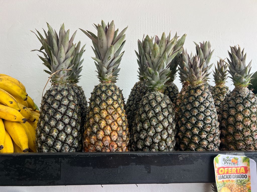 Abacaxis e bananas frescos na prateleira da loja